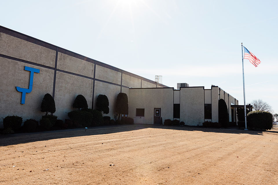 The front of the JTD facility with the american flag waving.