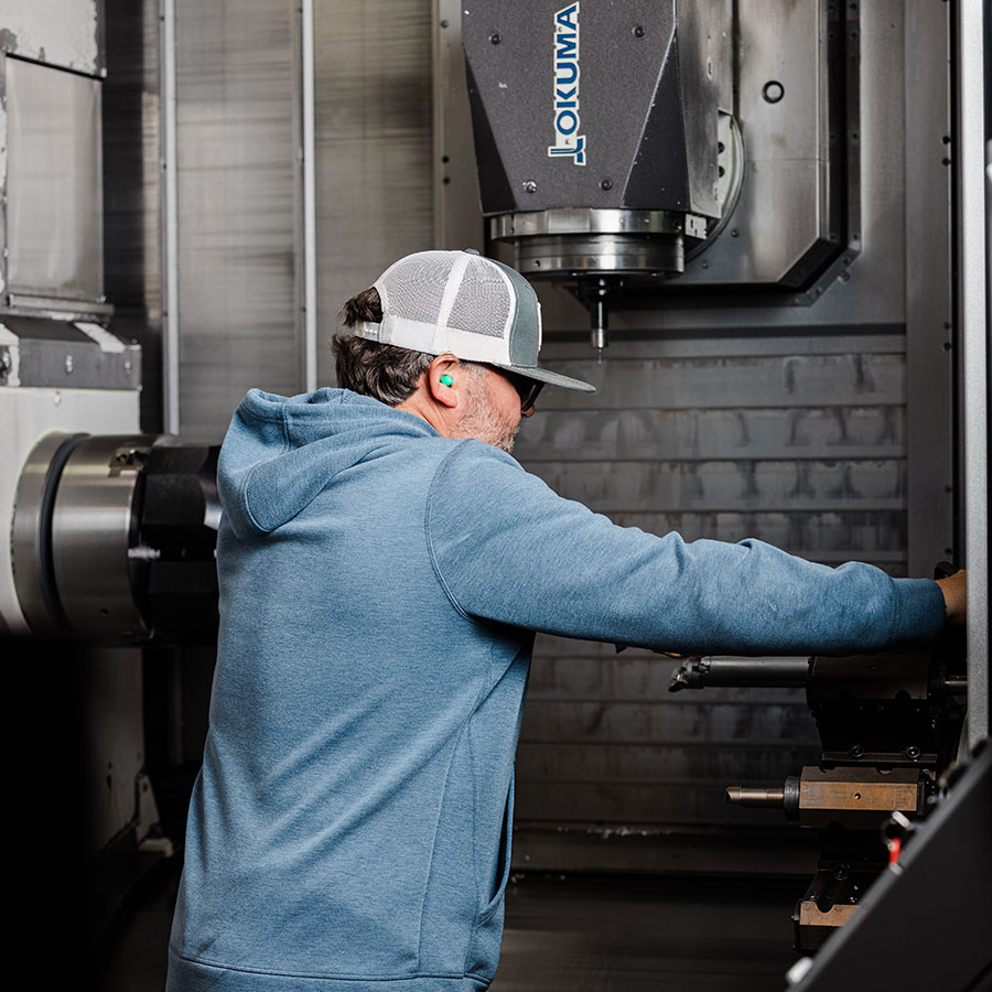 An employee working on the new Okuma Lathe machine at Jonesboro Tool and Die.