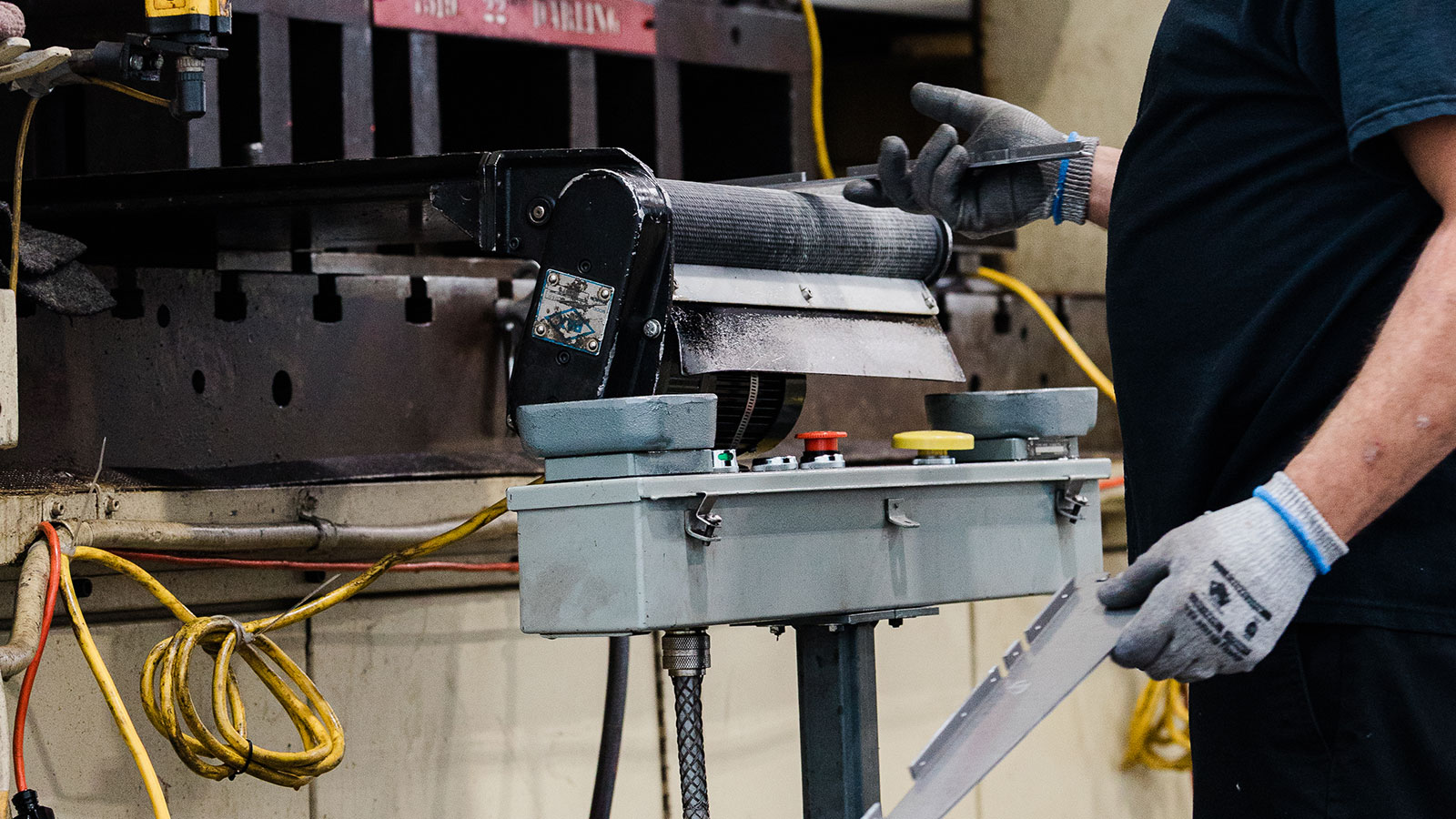 Punch press running production being watched by a JTD craftsman.