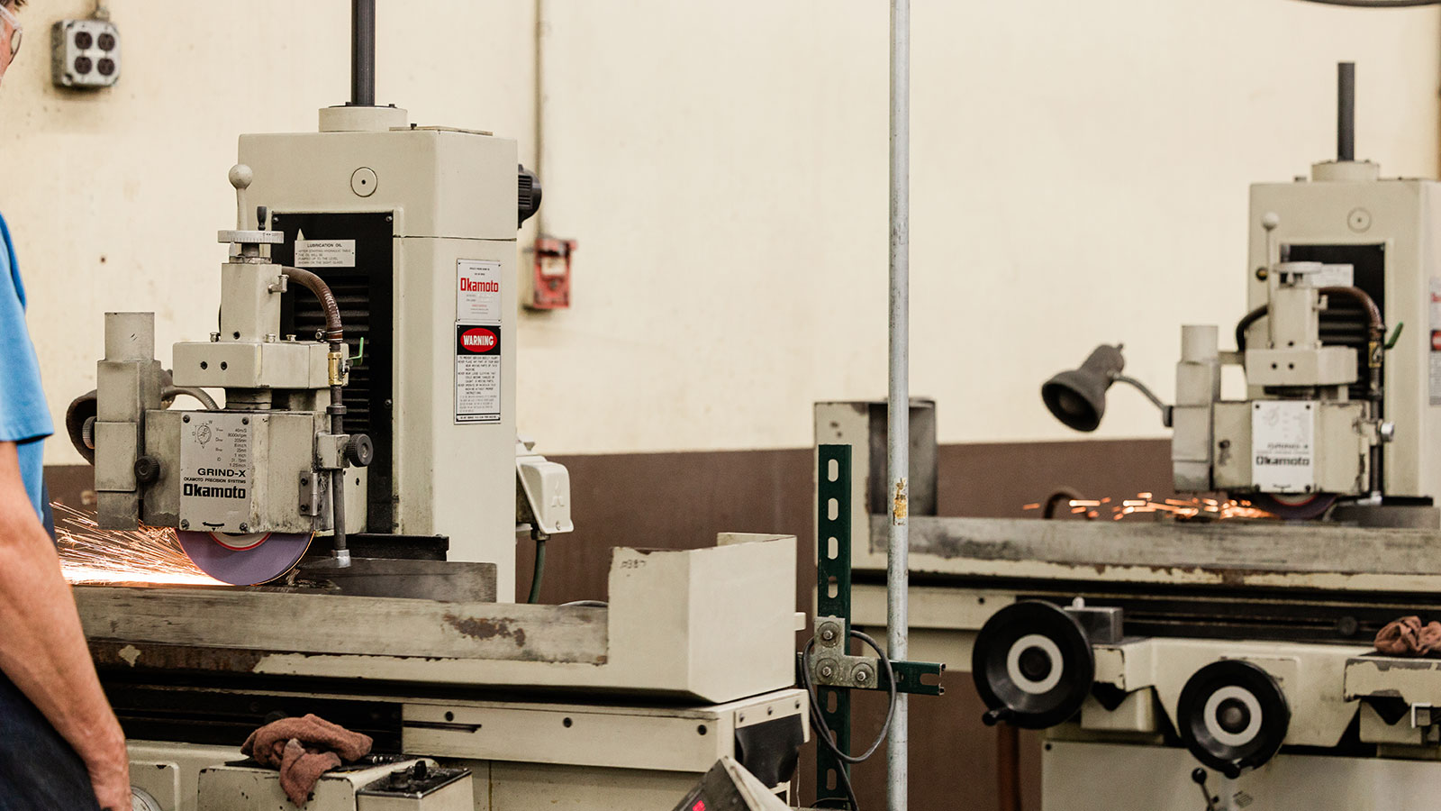 Jonesboro Tool and Die employee using the Okamoto ACC-618DX Series Saddle Type Surface Grinder.