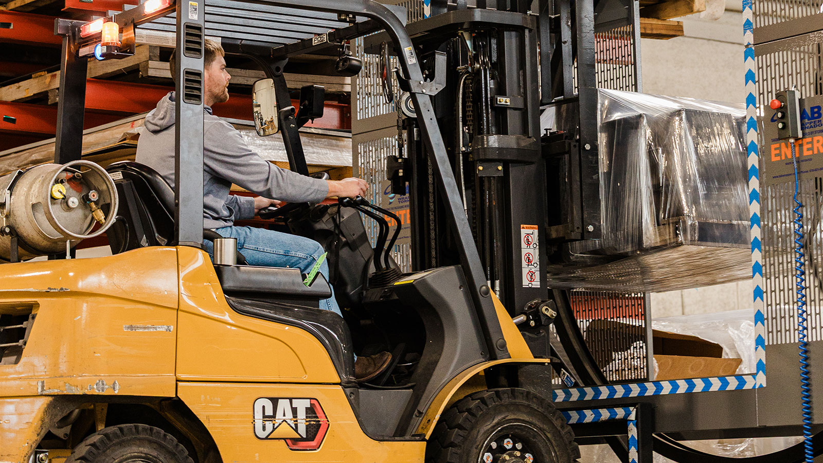 Zack using the Tornado automated pallet wrapper getting some parts ready to be shipped.
