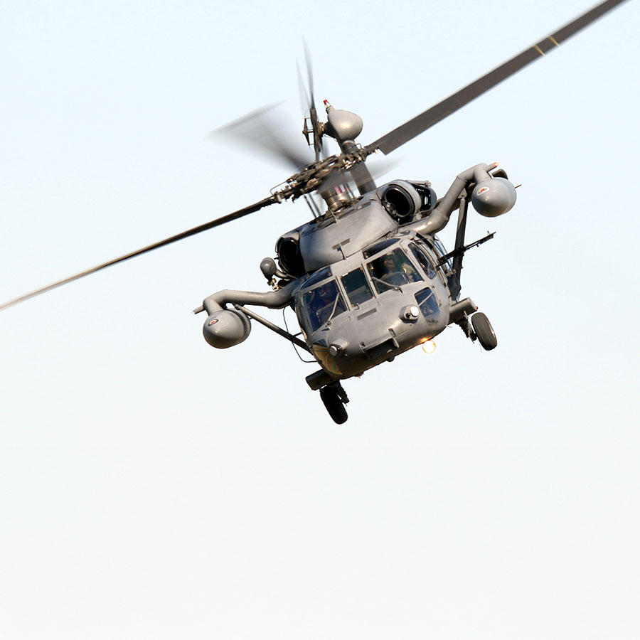 A military hawk helicopter flying in the sky.